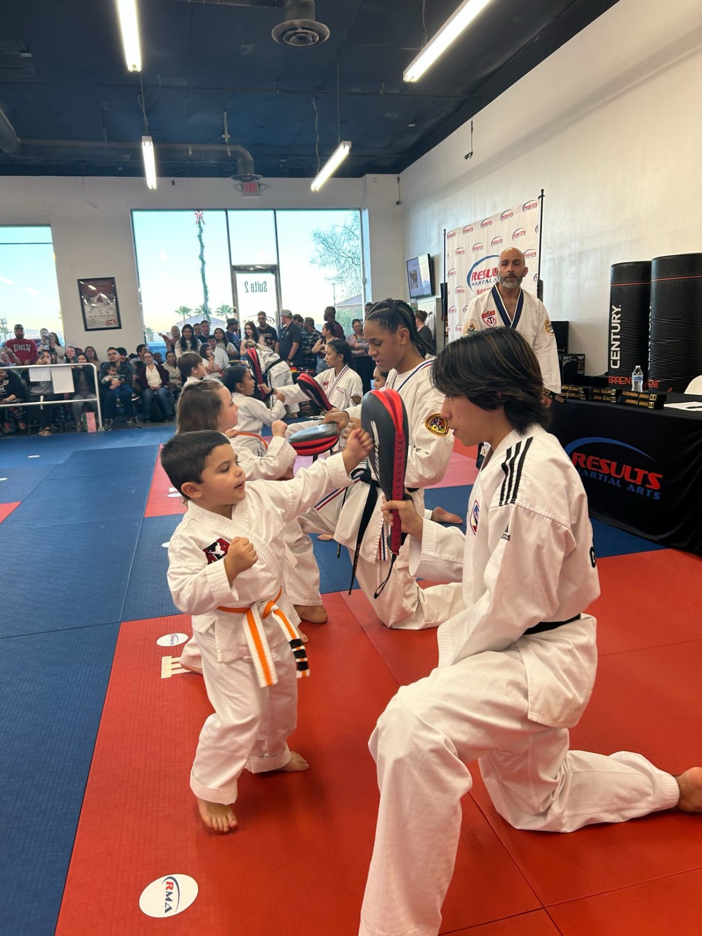 Orange-belt student locked in on a side kick