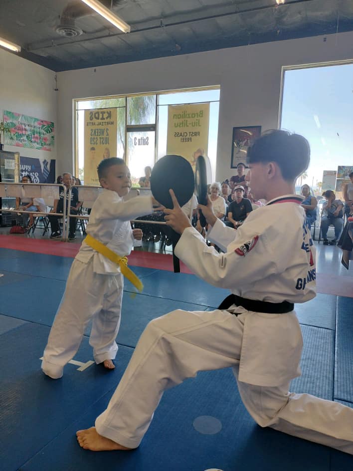 Coach holding pads for a Results Martial Arts student