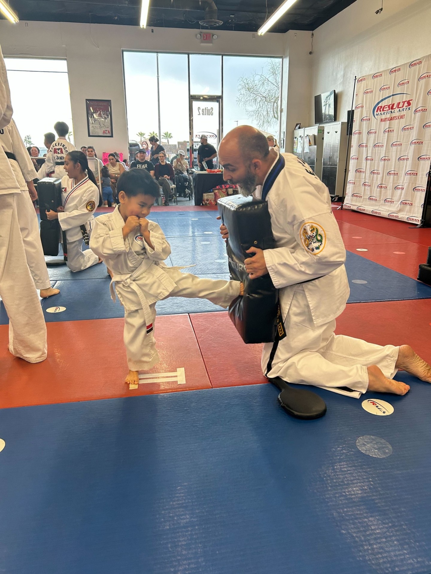 Tiny Tigers student delivering a kick under instructor guidance