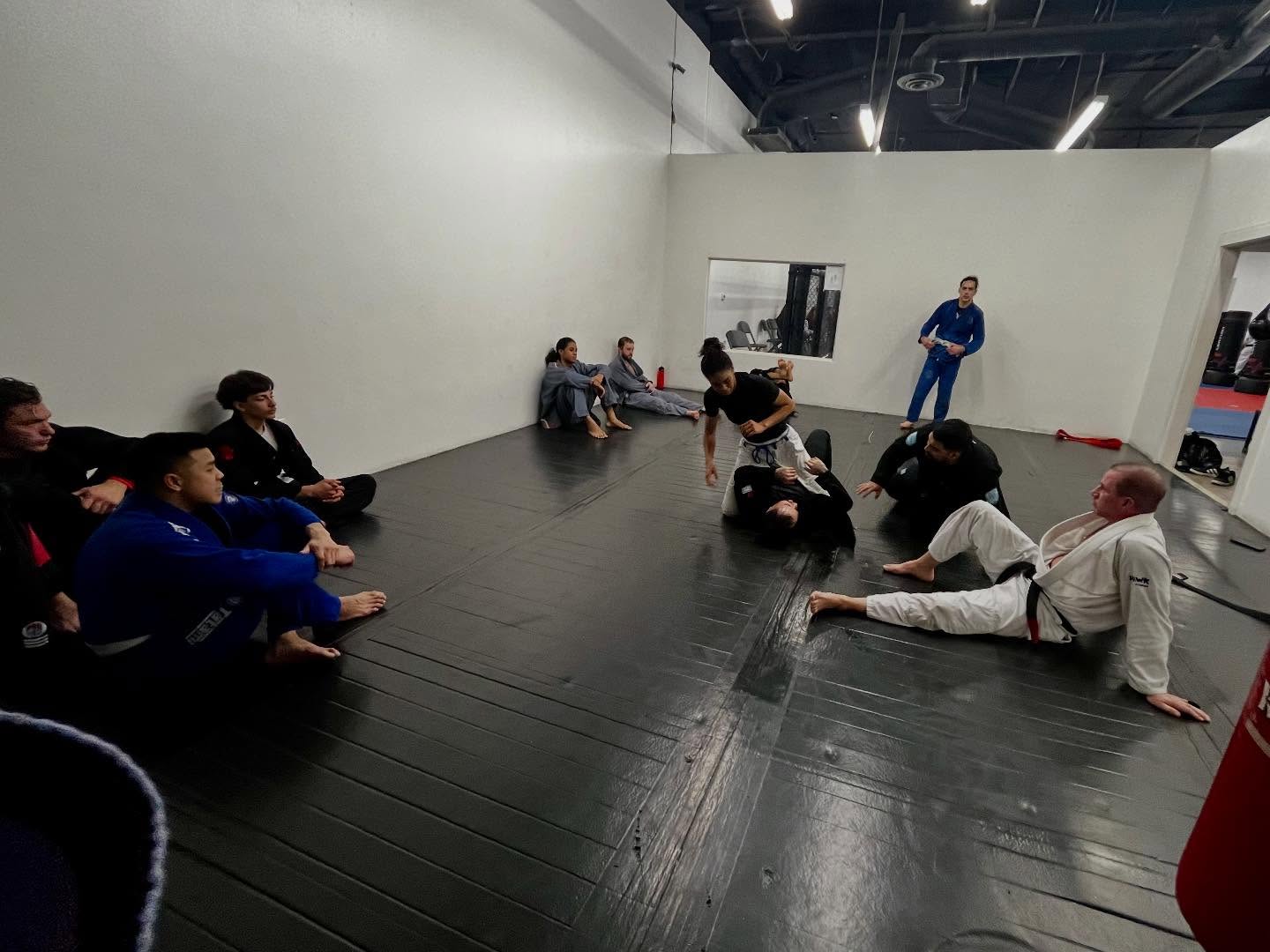 Adults rolling during a Brazilian Jiu-Jitsu round at Results Martial Arts
